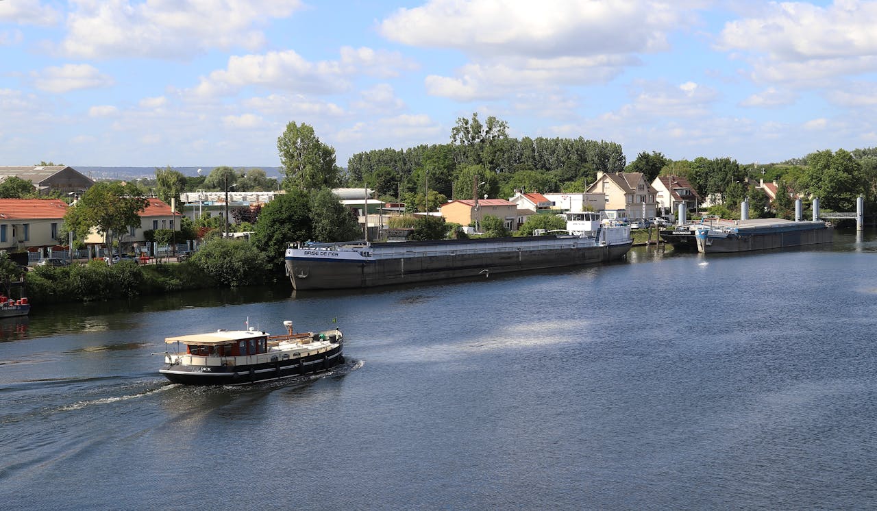 Motorboat cruising along the river in Conflans-Sainte-Honorine, France, on a sunny day.
