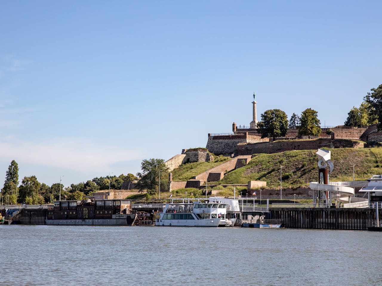 Scenic view of Belgrade Fortress overlooking the Sava River with boats docked.
